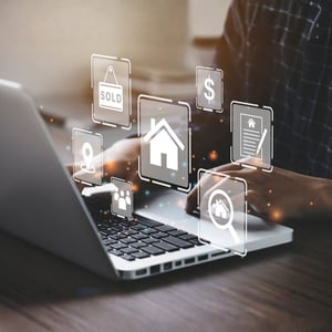 A person using a laptop with digital real estate icons overlaid on the screen, representing property listings, transactions, and technology-enabled customer service in real estate education or operations.