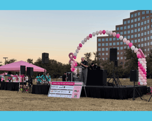 A stage with pink and white balloons at the Mary Kay 5K run