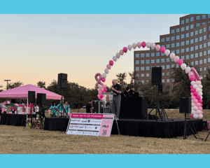 Stage with pink and white balloons at the Mary Kay 5K run for charity