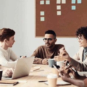 Three people sitting at a table drinking coffee