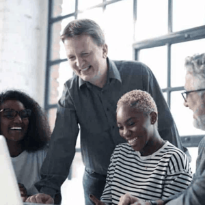 A group of people looking at a computer and smiling