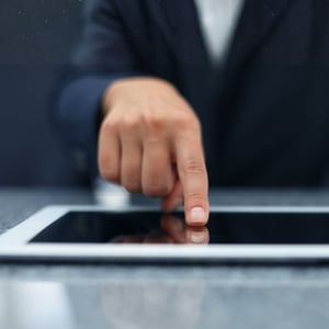 A hand touching a tablet screen