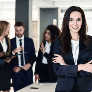 A business woman standing in an office with three other collegues in the background