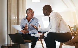 2 people in a business lounge discussing paperwork